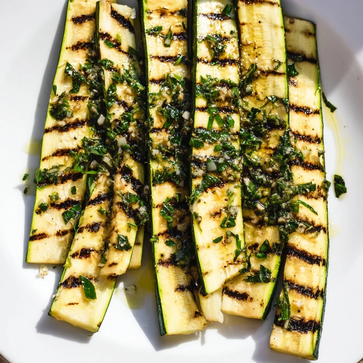 Flavorful Garlic Herb Grilled Zucchini, showing grill marks and glistening with olive oil and spices.