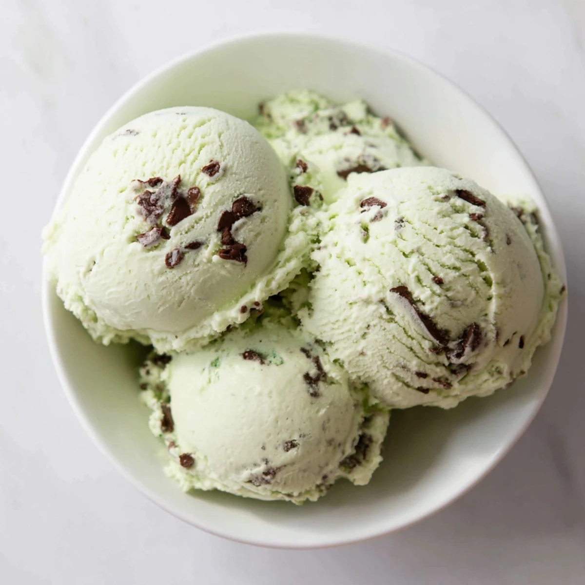 Creamy homemade Mint Chocolate Chip Ice Cream, swirled with visible chocolate chips, a cool treat.