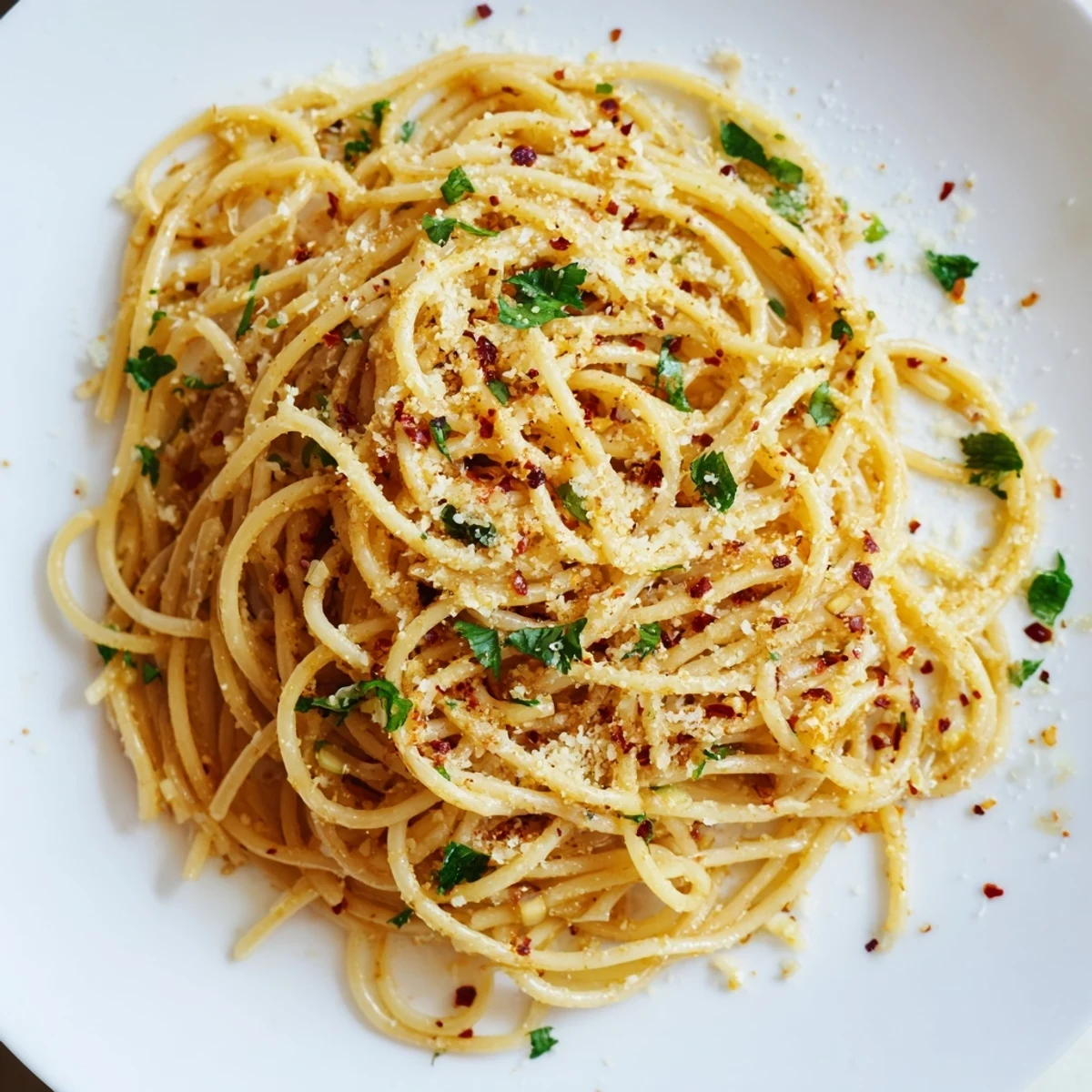 Steaming bowl of Aglio e Olio express pasta, golden garlic glistening atop spaghetti with parsley.