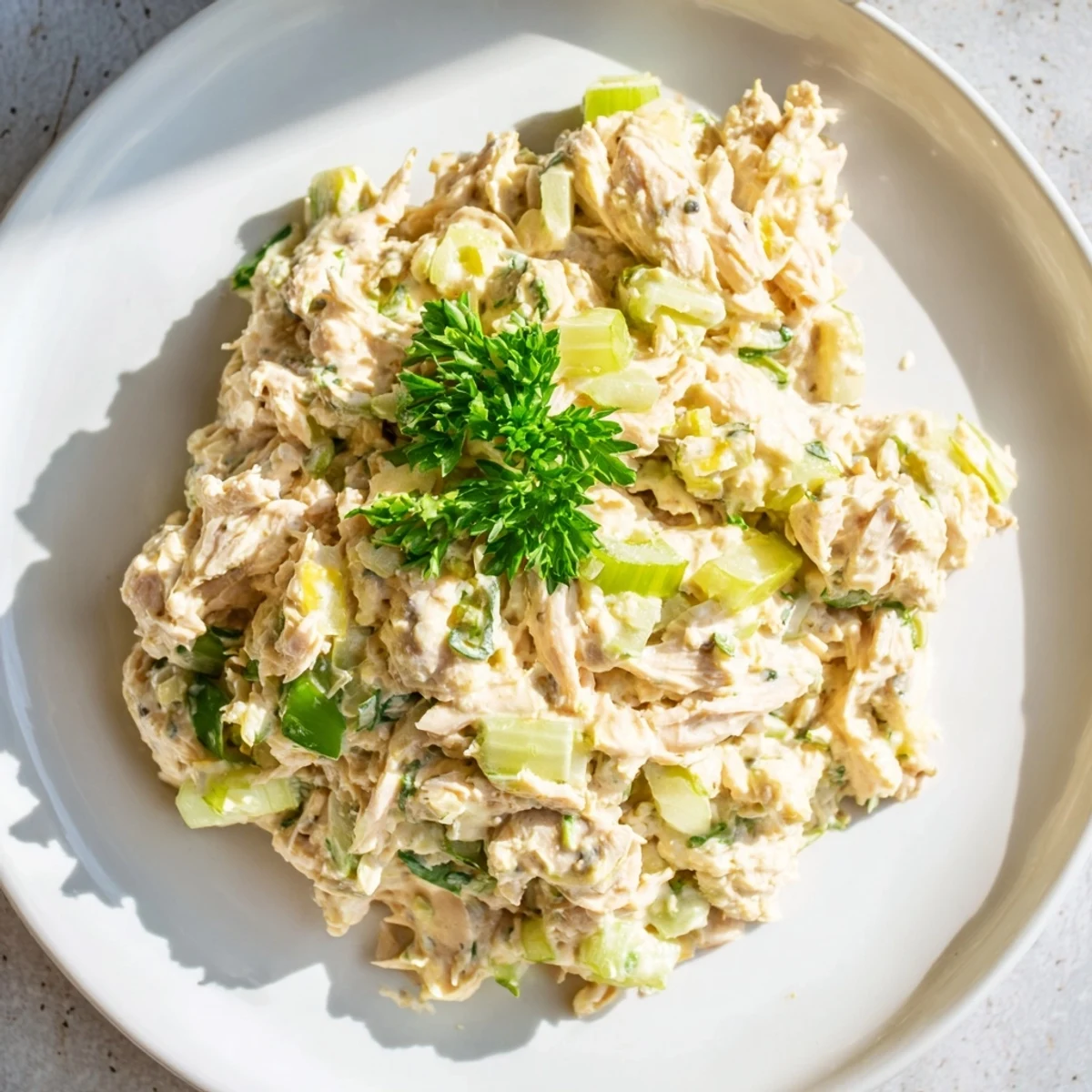 A close-up of the vibrant Spicy Zesty Tuna Salad, featuring flaky tuna tossed in creamy red sriracha mayo with fresh green scallions.