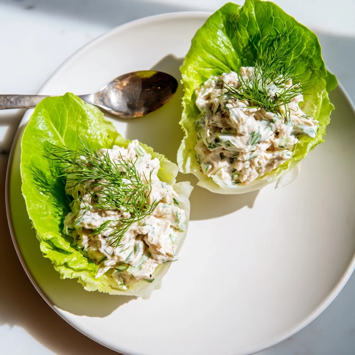 A close-up of a Dill Pickle Chicken Salad Lettuce Cup showing the crunchy celery and red onion mixed into the tender shredded chicken.