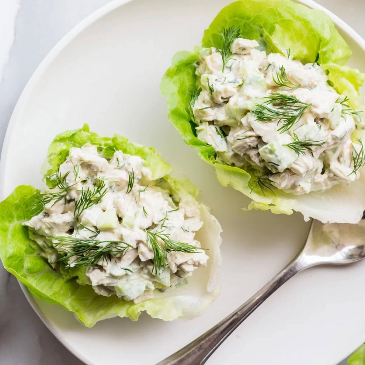 A platter of gluten-free Dill Pickle Chicken Salad Lettuce Cups arranged on a wooden board, ready for a light and flavorful low-carb lunch.
