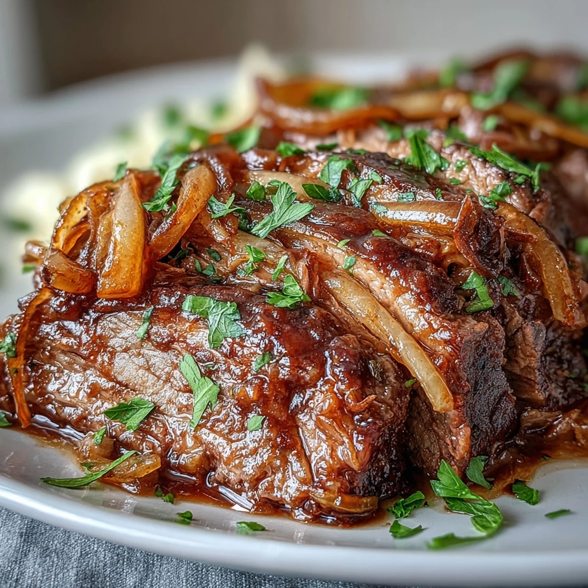 Tender slices of Savory Crock Pot French Onion Pot Roast served over mashed potatoes with rich, savory juices.