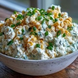 Spoonful of golden-baked Crack Corn Dip, a cheesy, creamy appetizer with bright green onions and jalapeños, perfect for game-day snacking or party gatherings.