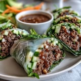 A vibrant close-up of Thai Basil Beef Rolls, showcasing colorful vegetables and herbs wrapped in soft, translucent rice paper.