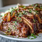 Tender slices of Savory Crock Pot French Onion Pot Roast served over mashed potatoes with rich, savory juices.