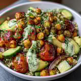 Zesty lemon vinaigrette drizzled over hearty grain bowls with roasted chickpeas and fresh vegetables.