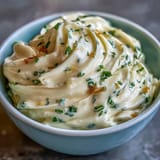 Rich homemade garlic aioli with a smooth, glossy texture, ideal as a spread for sandwiches or a sauce for seafood.