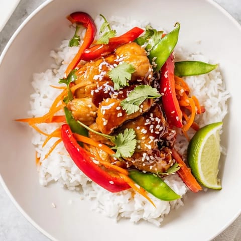 Close-up of a flavorful Sesame Ginger Rice Bowl: tender chicken over fluffy rice, ready to eat.