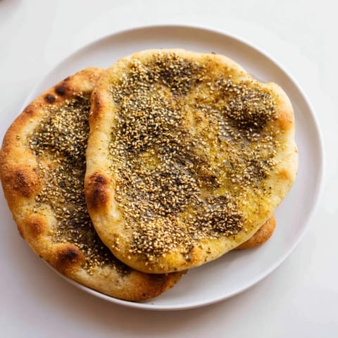 Warm, freshly baked Levantine Zaatar Bread with a crispy crust and savory zaatar topping.