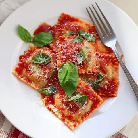 Steaming ravioli with ricotta and spinach, ready to be served with extra Parmesan.  