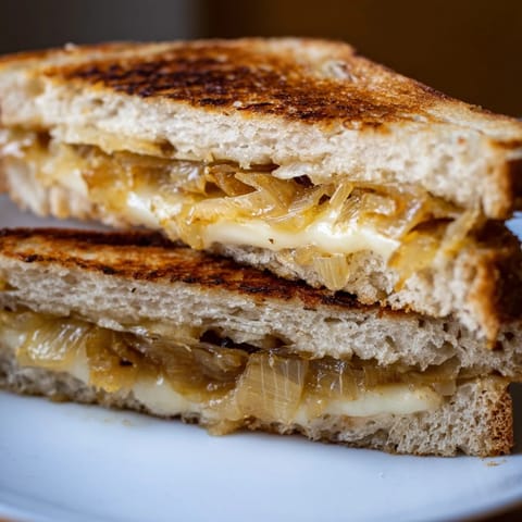 Golden-brown bread encases creamy Havarti and savory leeks for a delicious Havarti & Caramelized Leek Grilled Cheese.