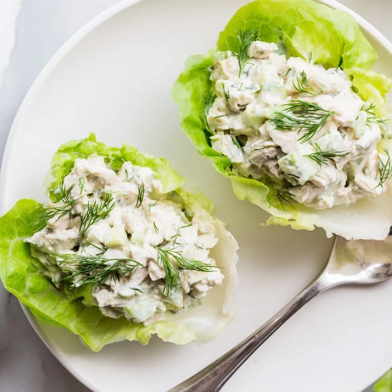 A platter of gluten-free Dill Pickle Chicken Salad Lettuce Cups arranged on a wooden board, ready for a light and flavorful low-carb lunch.