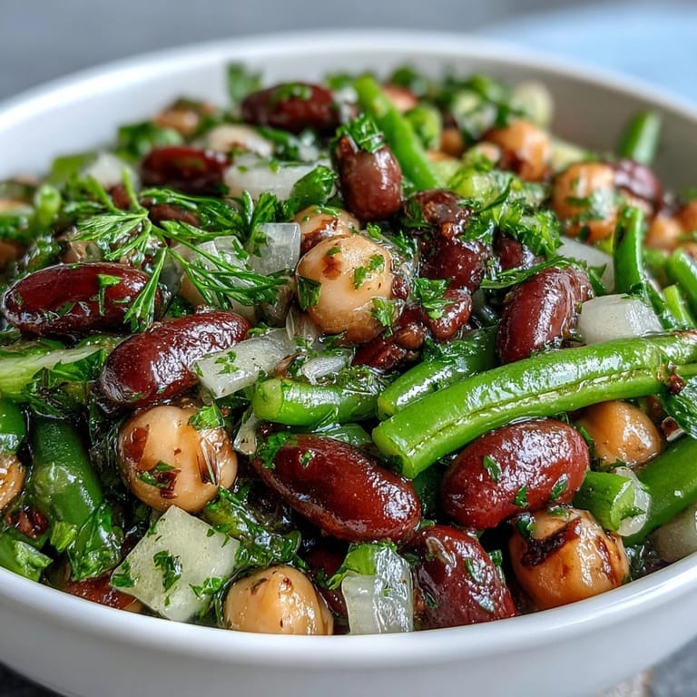 A vibrant Three-Bean Salad made with crunchy vegetables and a sweet-tart dressing, perfect for summer picnics.