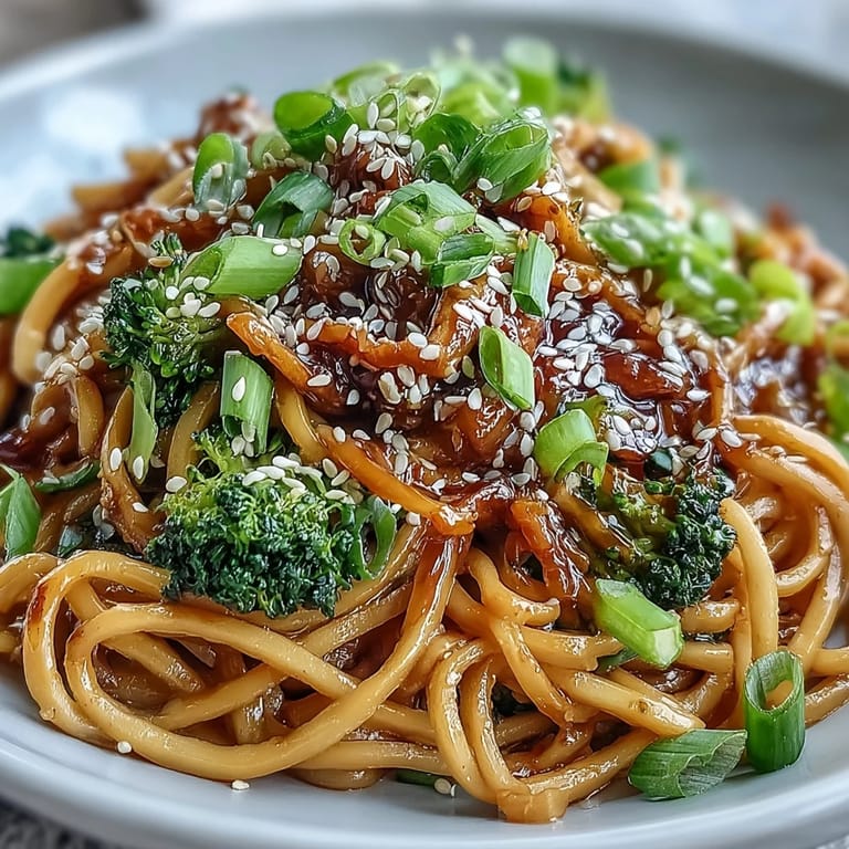 Steaming Asian Teriyaki Noodle Bowl in a ceramic bowl, garnished with fresh green onions and chopsticks ready for a quick weeknight dinner.