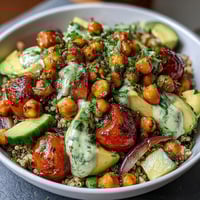 Zesty lemon vinaigrette drizzled over hearty grain bowls with roasted chickpeas and fresh vegetables.
